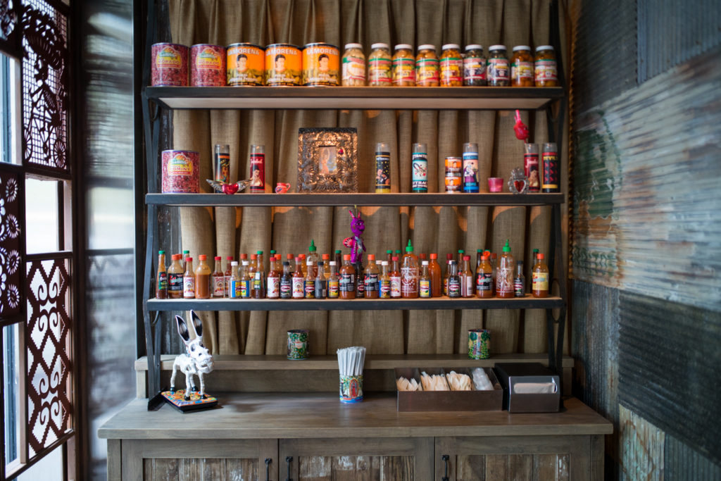 Restaurant decor, including jars, hot sauces, and candles