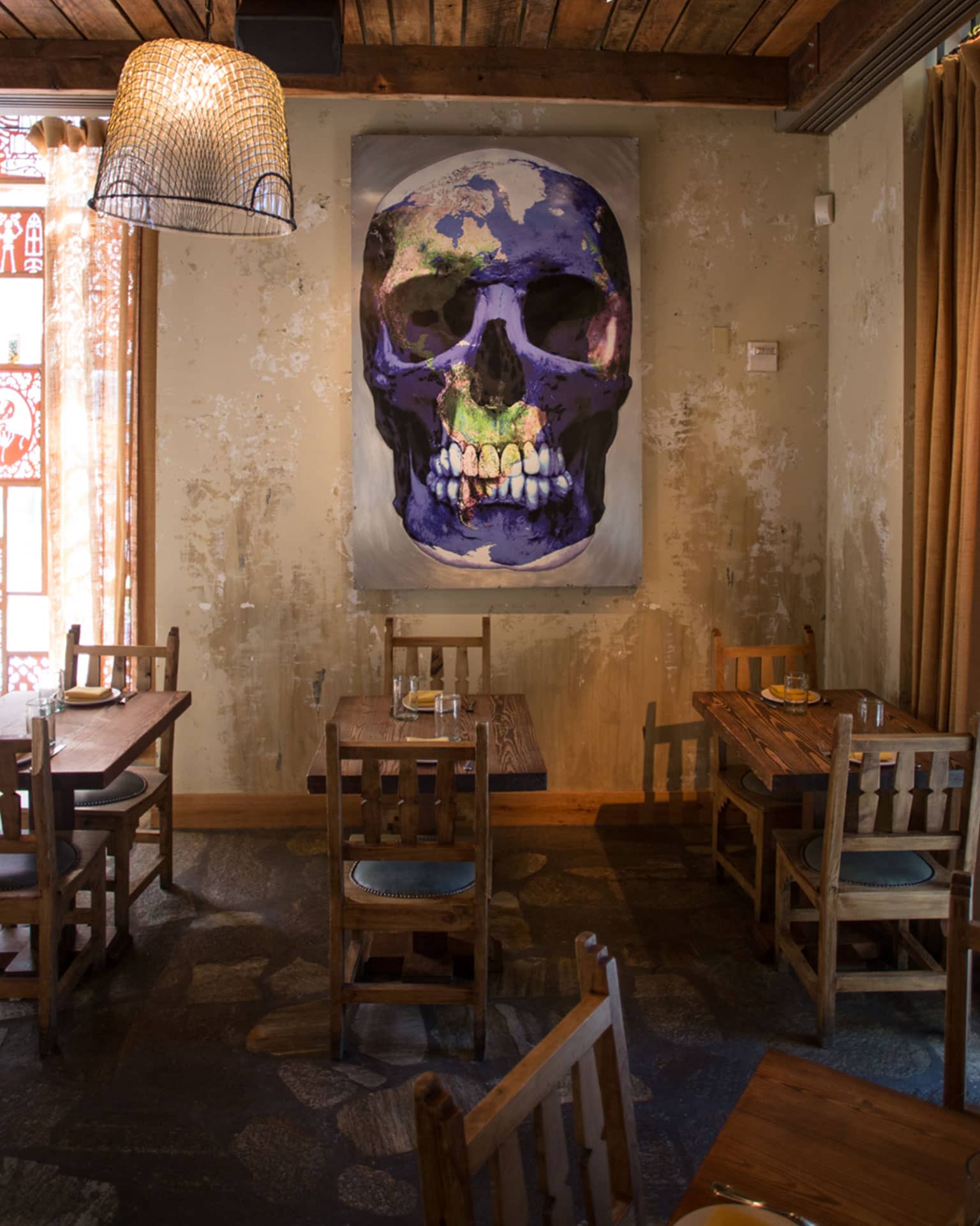 Dining room and decor, including a painting of a skeleton